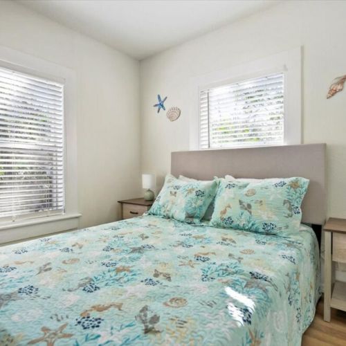 Upstairs guest bedroom 2 with full bed and two night stands and closet.